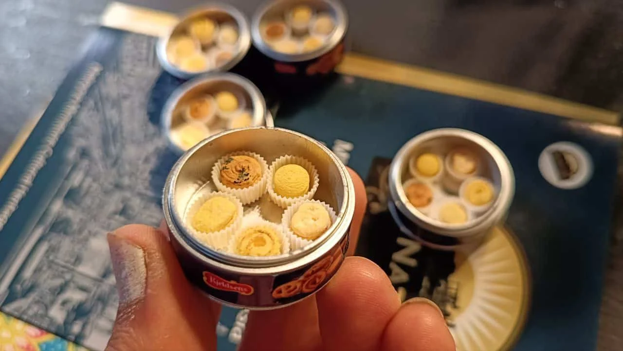 Tiny handmade dim sum basket held between fingertips, showing the miniature scale